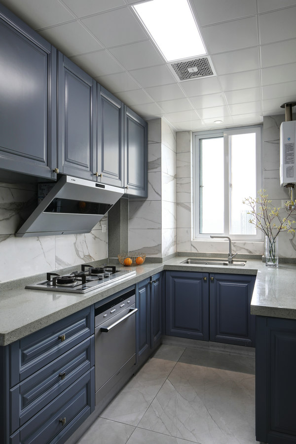 U型厨房布局动线设计巧妙，蓝色橱柜工作台颜色相得益彰，在浅色空间中倍感静谧。