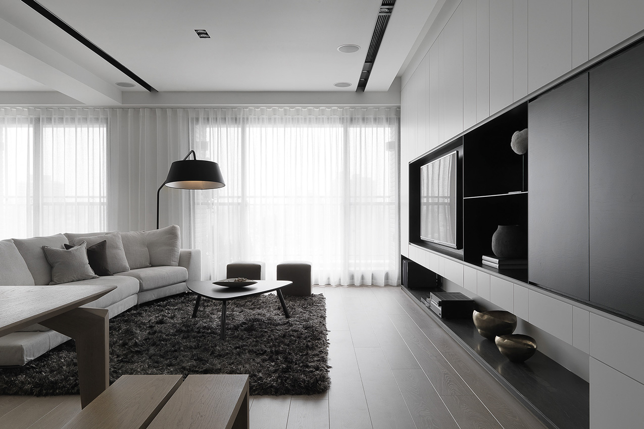 客厅摆放着灰白色布艺沙发，触感舒适的地毯为客厅增添了些许层次感。