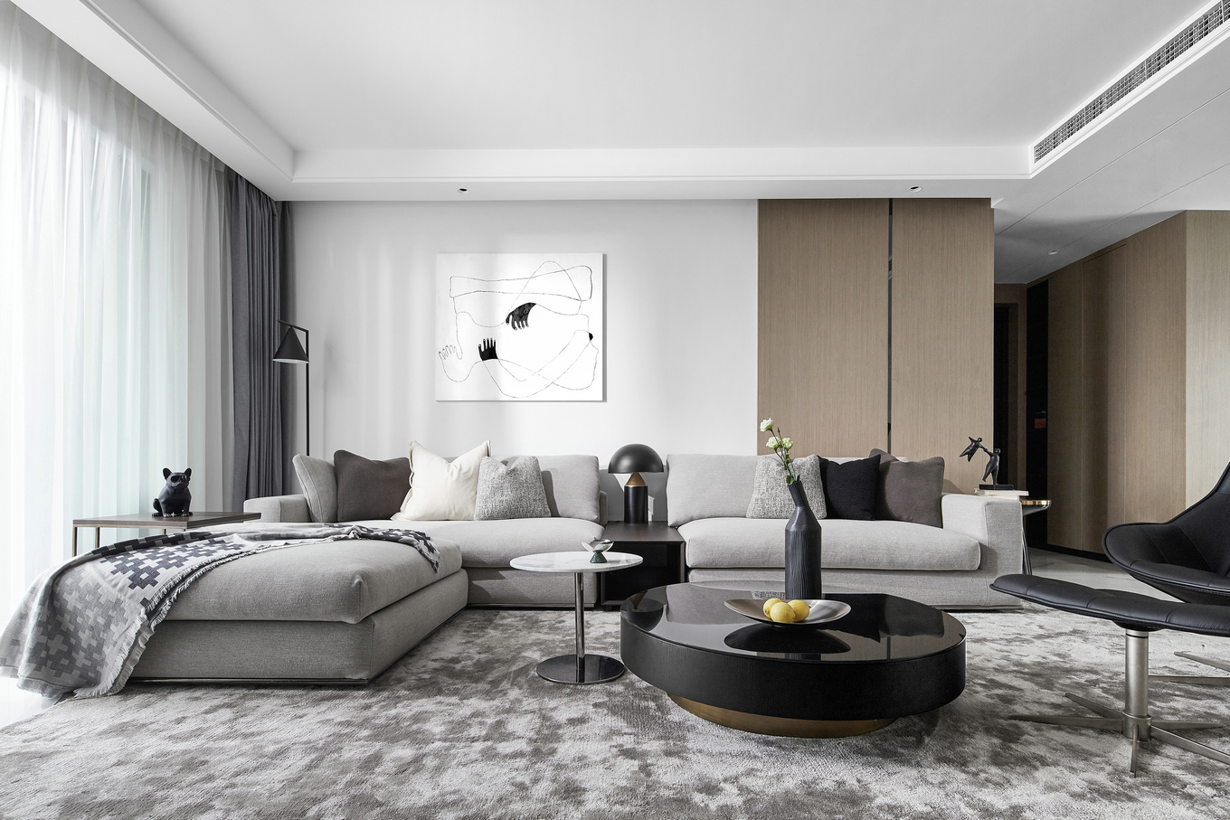 高级灰布艺沙发搭配绒面地毯，加一黑色沙发椅，绽放高品质生活；白色墙漆+木板拼接的背景墙，丰富有质感