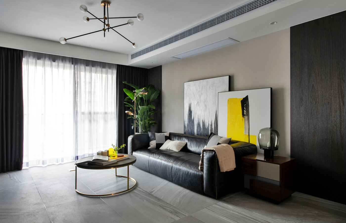 米色背景墙搭配黑色沙发，整体空间更为大气自然，局部放置艺术挂画，空间满满的文艺感。