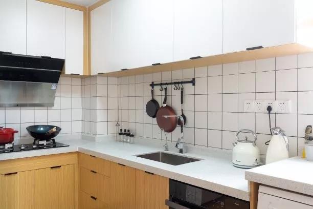 厨房空间采用白色与木色结合，木质橱柜与白色吊柜表现出日式风格的柔美。