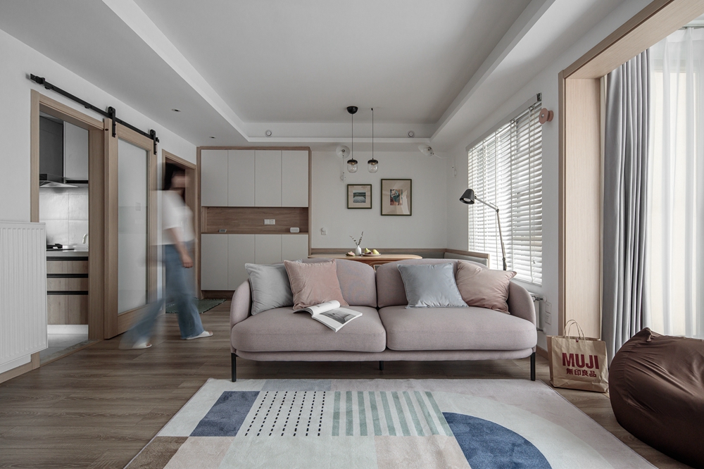 客厅以浅色调打造，家具简洁造型，沙发成为空间隔断，营造出温和静谧之感。