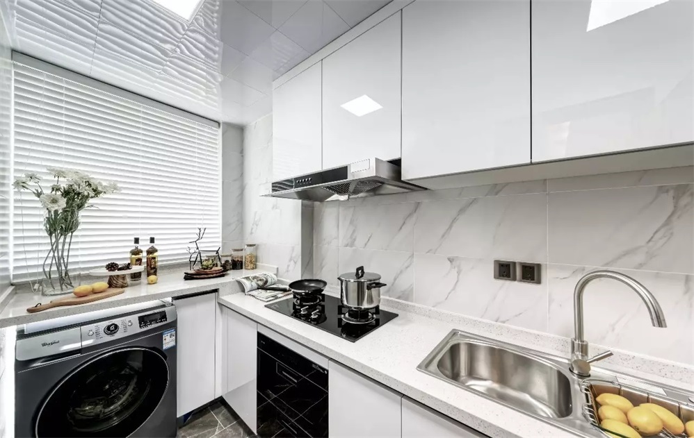 厨房明亮洁净，白色空间中使用烤漆材质的橱柜，增加了空间的层次变化。