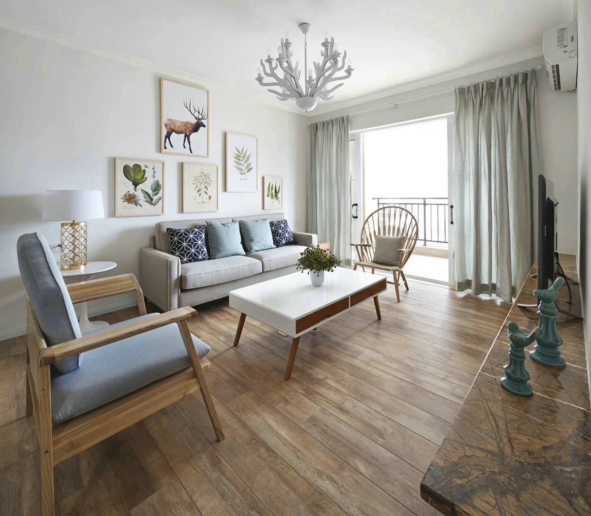 客厅白色的背景墙和灰色的布艺沙发搭配，空间显得更加简洁自然。
