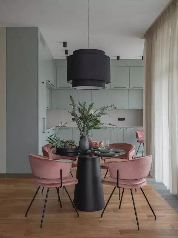 黑色餐桌与吊灯相互户型，粉色绒质细腿餐椅让空间显得更加现代简雅而大方。