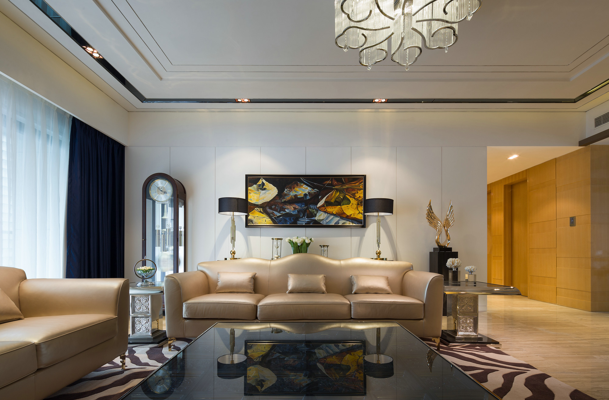 客厅白色背景墙搭配香槟色皮质沙发，营造出奢雅、素净的空间氛围。