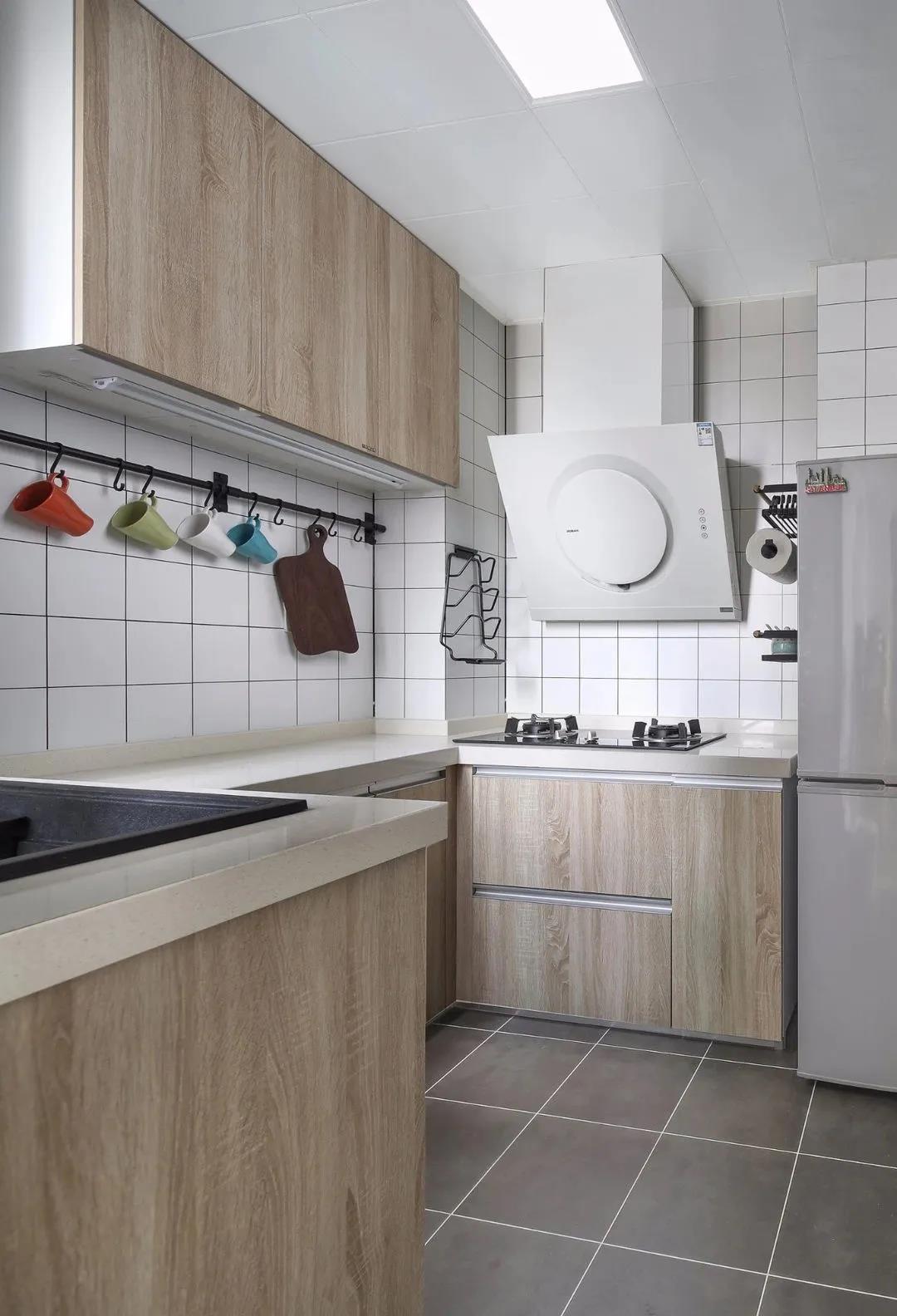 厨房暖色调处理，搭配木色橱柜，房间整体空间开敞明亮，动线设计合理全面。