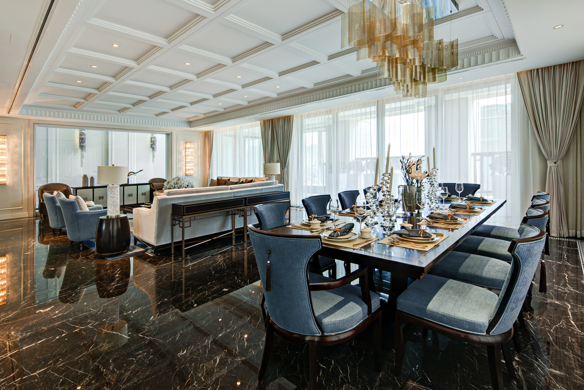 餐厅与客厅相连，蓝色餐椅与木色餐桌搭配巧妙，餐具选取跳跃的金色点缀其中，极富低奢时尚感。