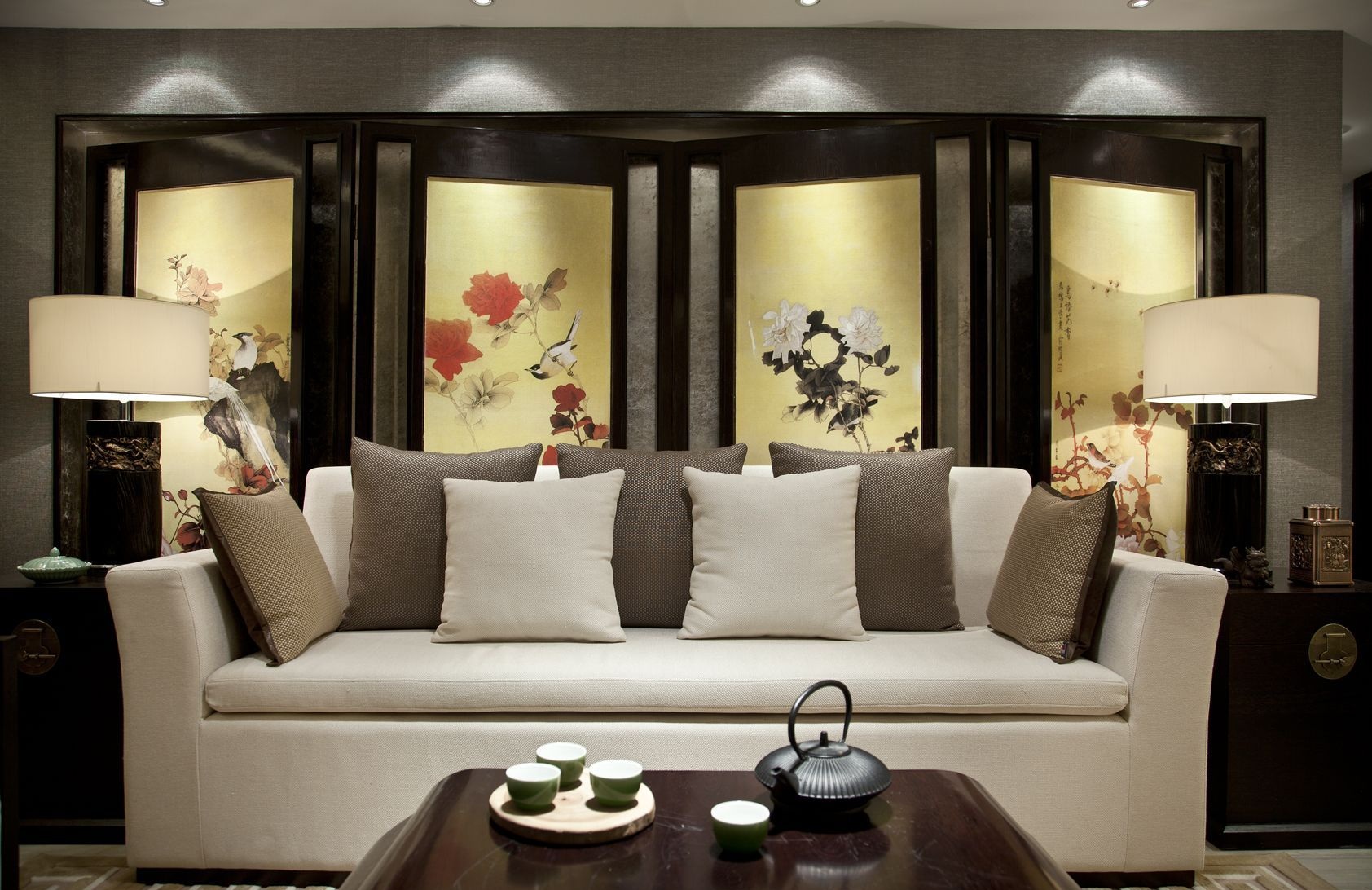 背景布局上采用的经典新中式屏风造型，突出轴线的对称，呈现出高雅静谧的客厅氛围。