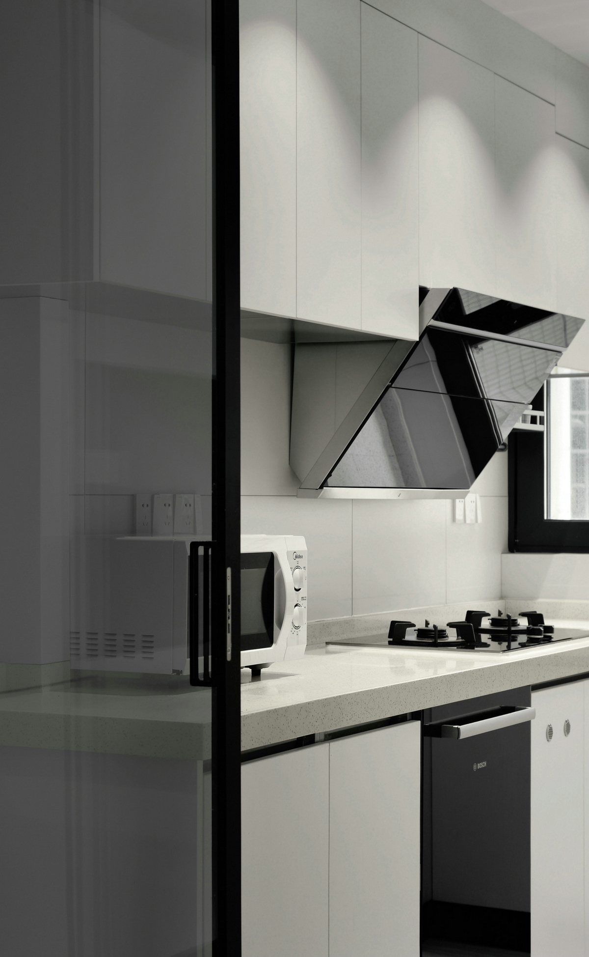 设计师利用玻璃门把厨房空间变得更加私密，空间中没有做过多装饰，简洁大气，不失时尚感。