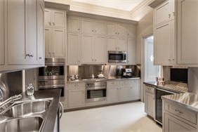 厨房空间充满优雅与质感，雅色橱柜搭配白色背景，呈现出一个舒适自由的烹饪氛围。