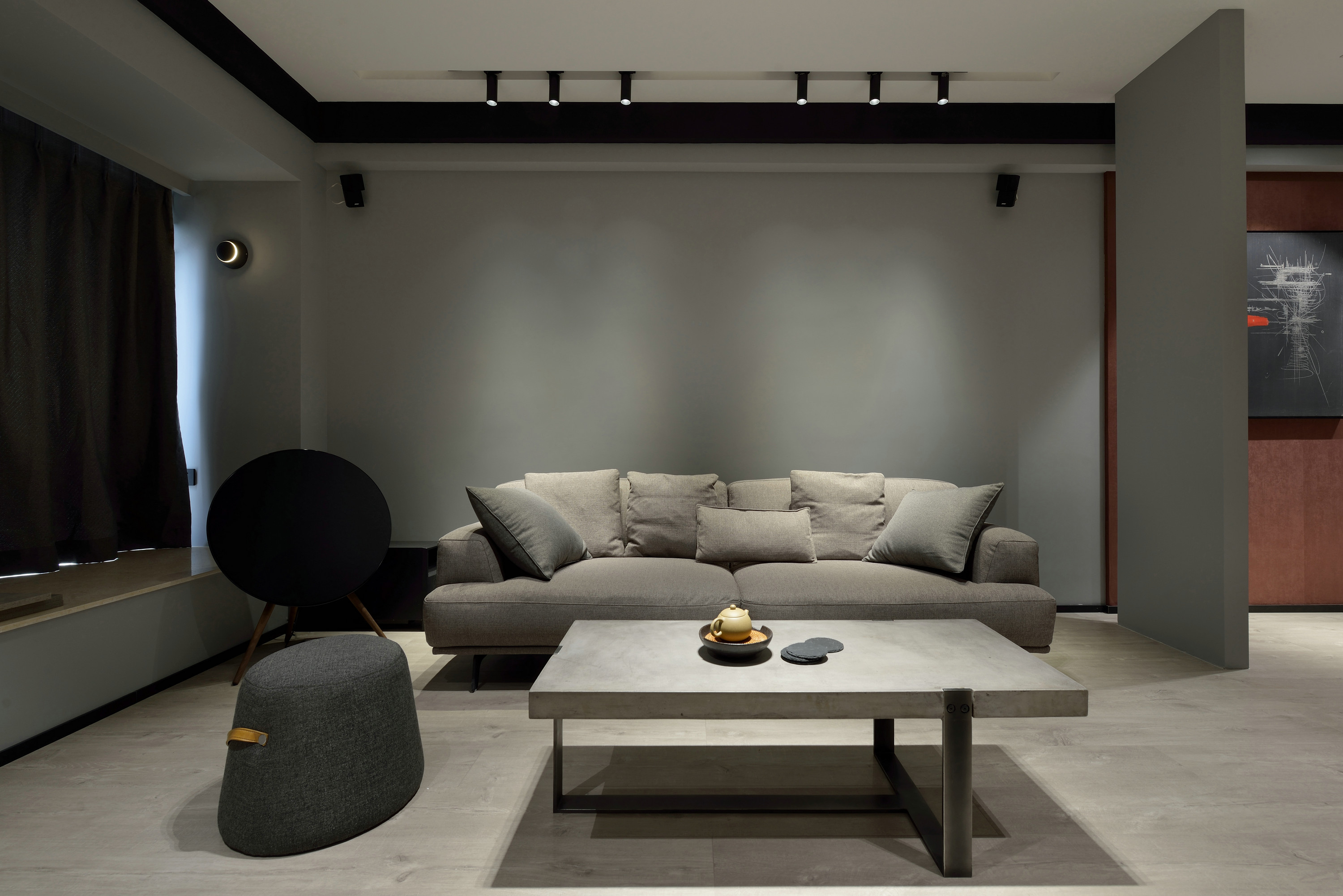 米灰色墙面自带工业气息，搭配布艺沙发，整个空间笼罩在俊雅悠然的气质中。