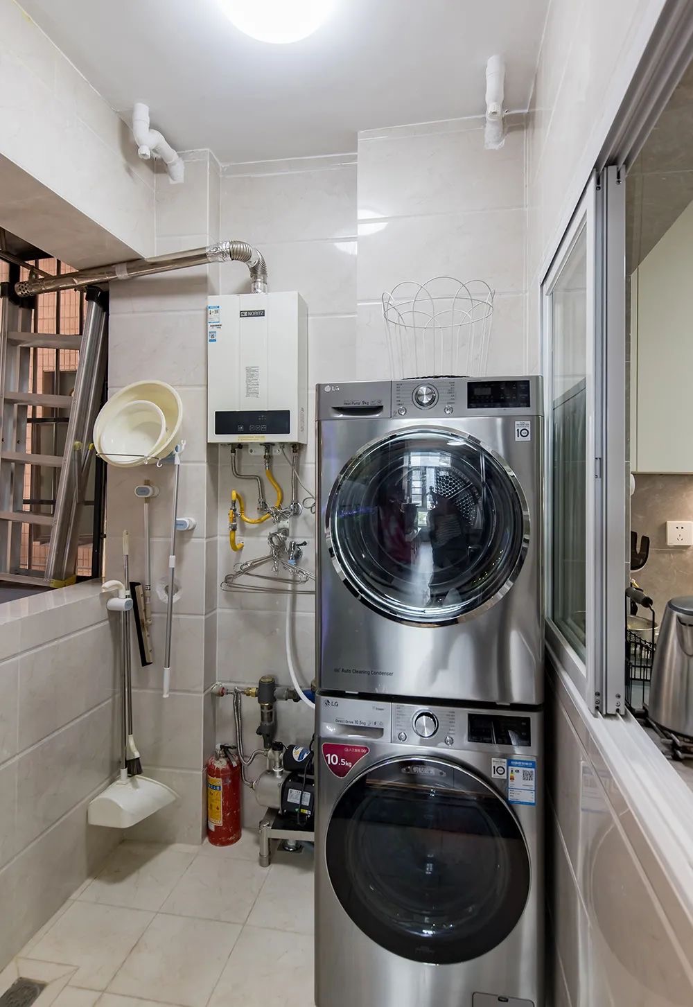 洗衣房结构紧凑，洗衣机上下放置节省了占地空间，整体以白色瓷砖铺设。