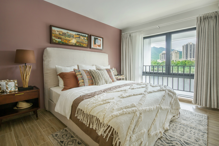 白色双人床搭配简约的粉色墙面，次卧空间简净而通透，为主人带来简素有度的体验。