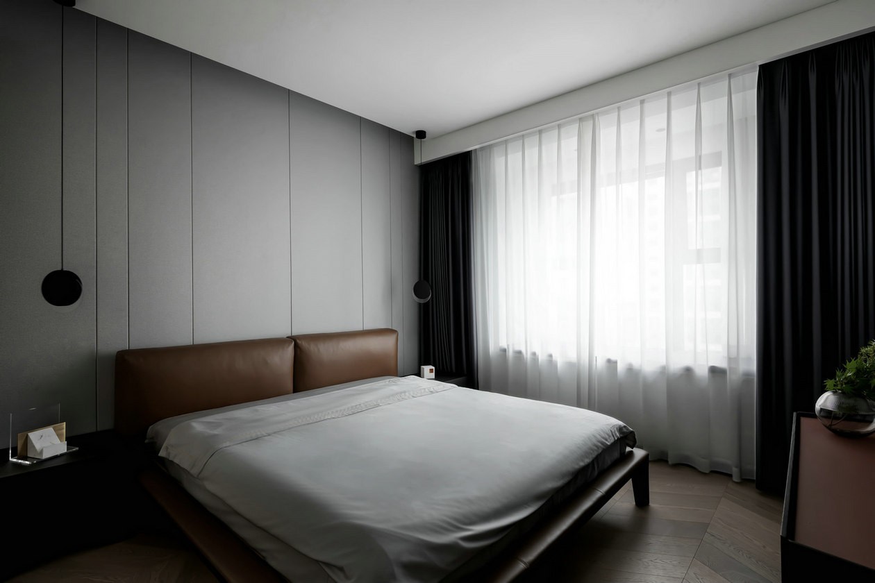 男主人希望空间有包容性，设计师使用灰色作为背景墙，搭配橘色皮质床头，格调讲究。