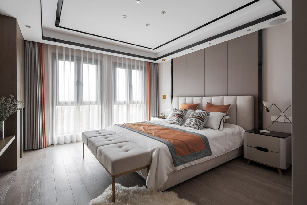 主卧颜值爆表，咖色软包背景墙搭配米色床头，局部使用橘色点缀，精致不凡。