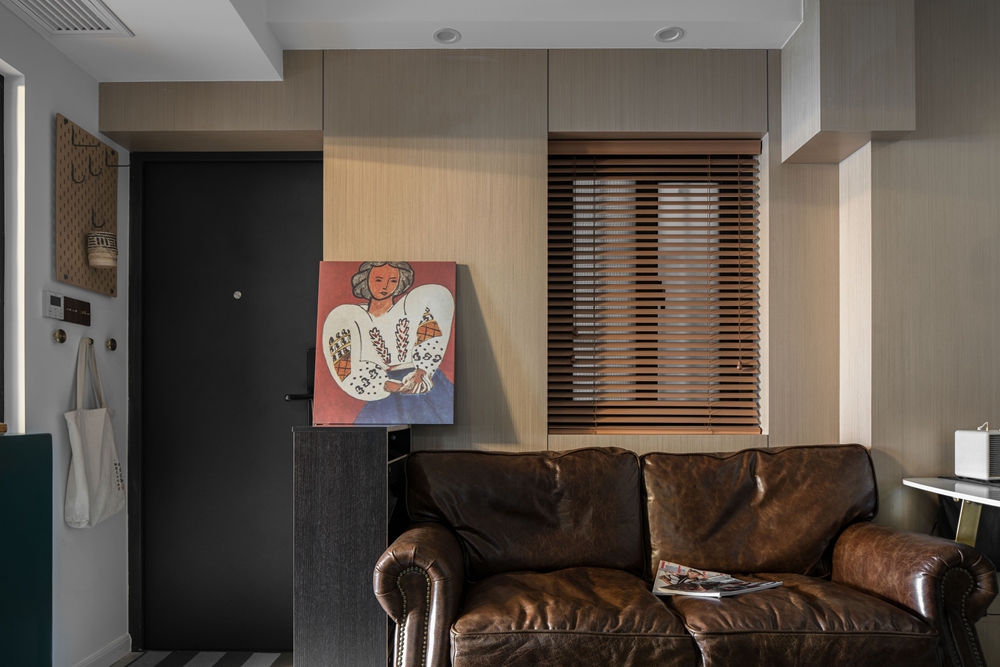 客厅设计层次分明，主调为米色，咖色皮质沙发与原木背景墙相互交融，营造出良好的氛围感。