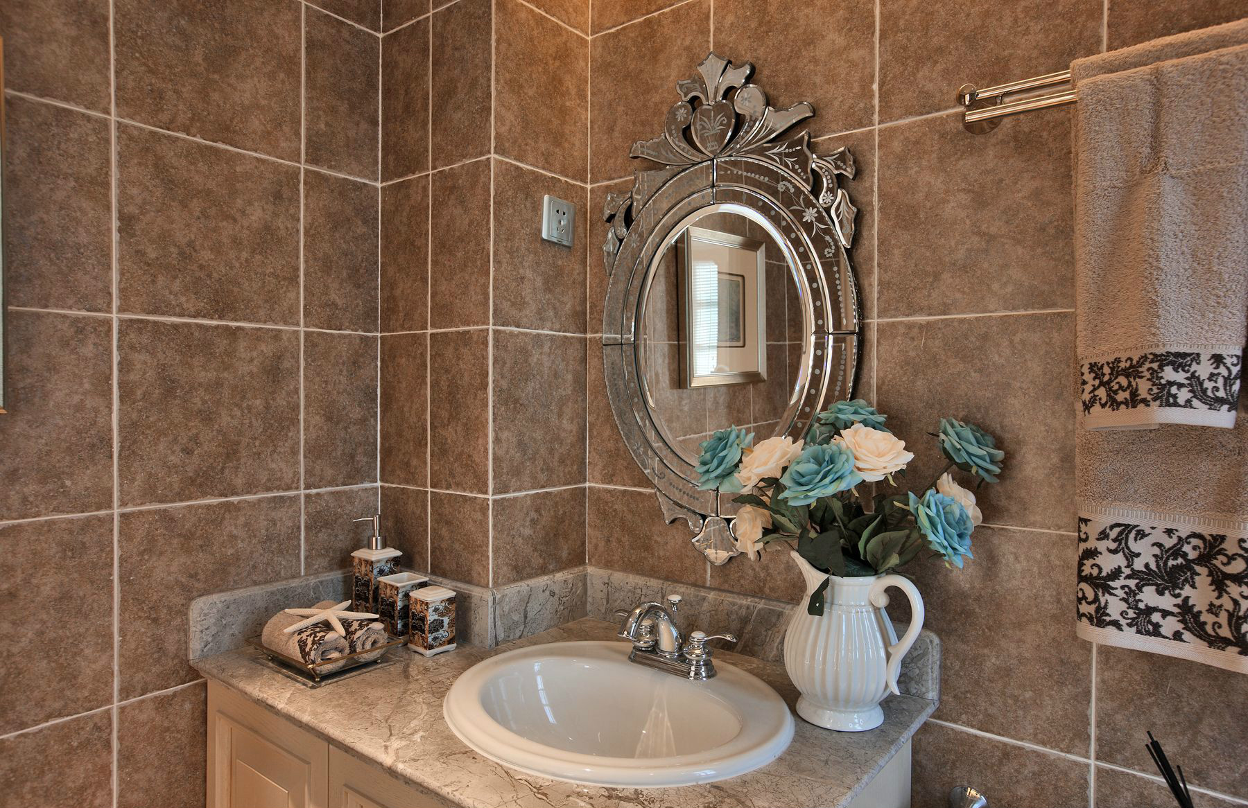 卫浴间以咖色做底，在材质的运用上设计师充分传递法式美学和艺术，彰显出干净纯粹的空间氛围。