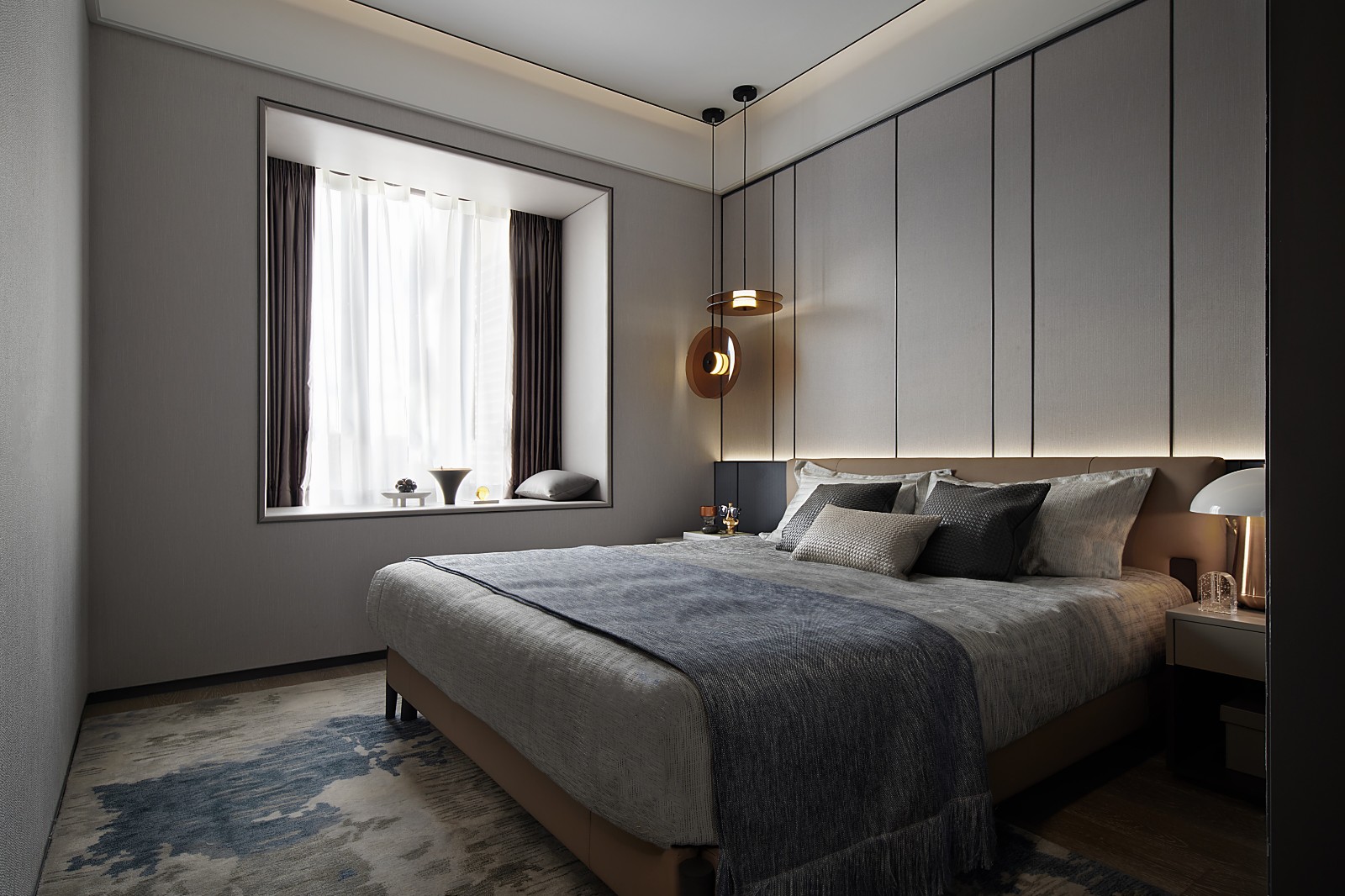 次卧背景墙材质较为独特，床头配以垂吊灯具，布置出一种简约而又高级的效果。