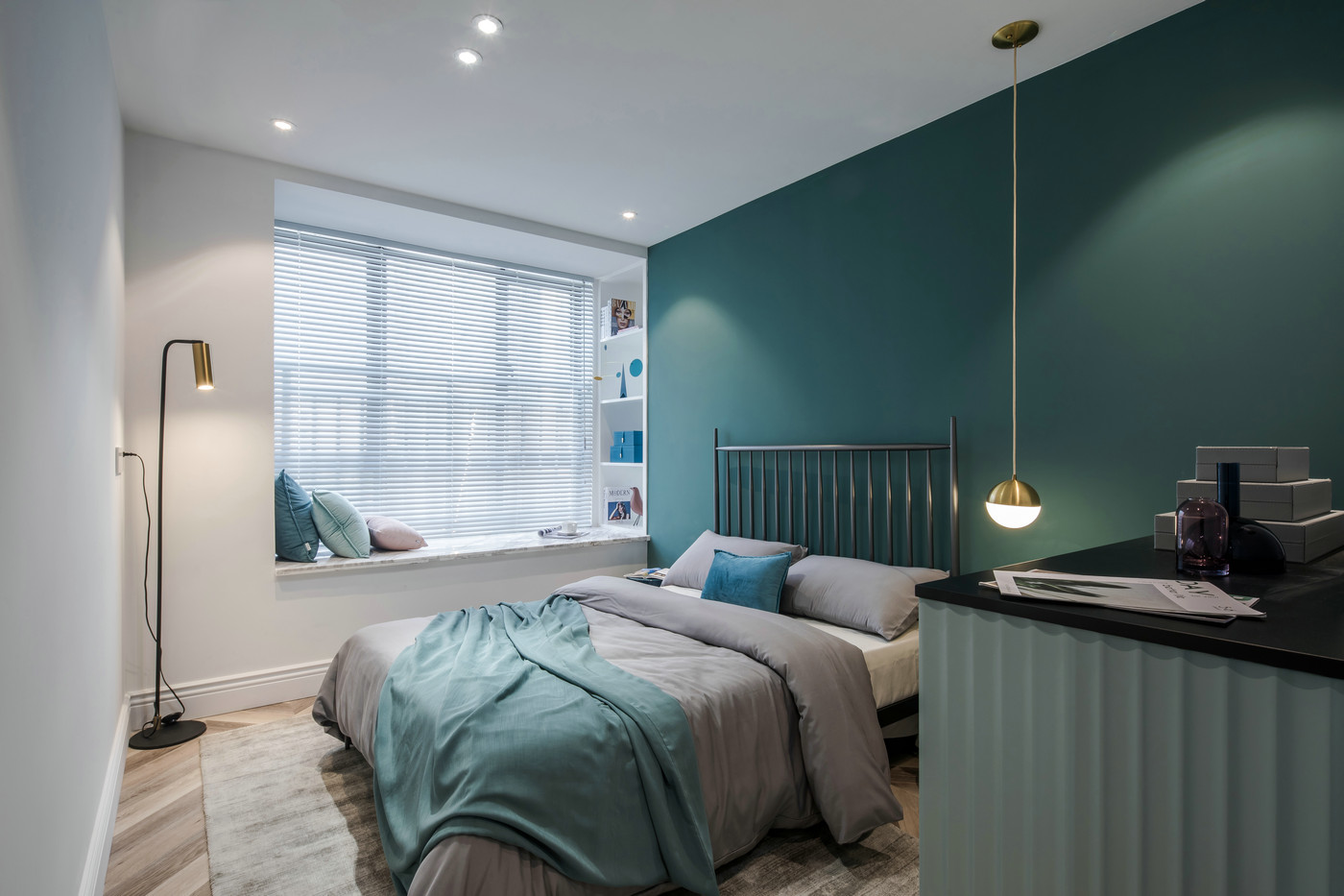 绿色背景墙设计简约，床头垂吊灯具为空间带来了丰富的细节质感。
