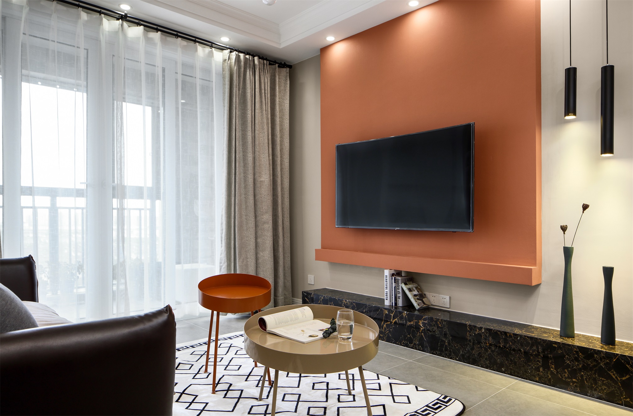 客厅通透明亮宽敞，橘色电视背景墙很抢眼，营造出一个时尚素雅的空间。