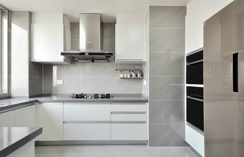厨房以灰白色为主，搭配线条简明的橱柜设计，营造出恬淡的居家氛围。