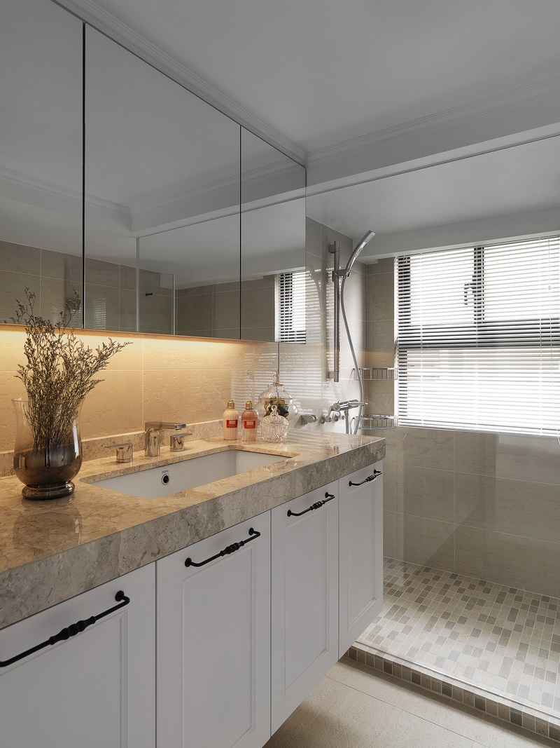 卫生间设计素雅简约，洗手台浴室镜延伸了空间的视觉感，给人以清爽舒适的感受。