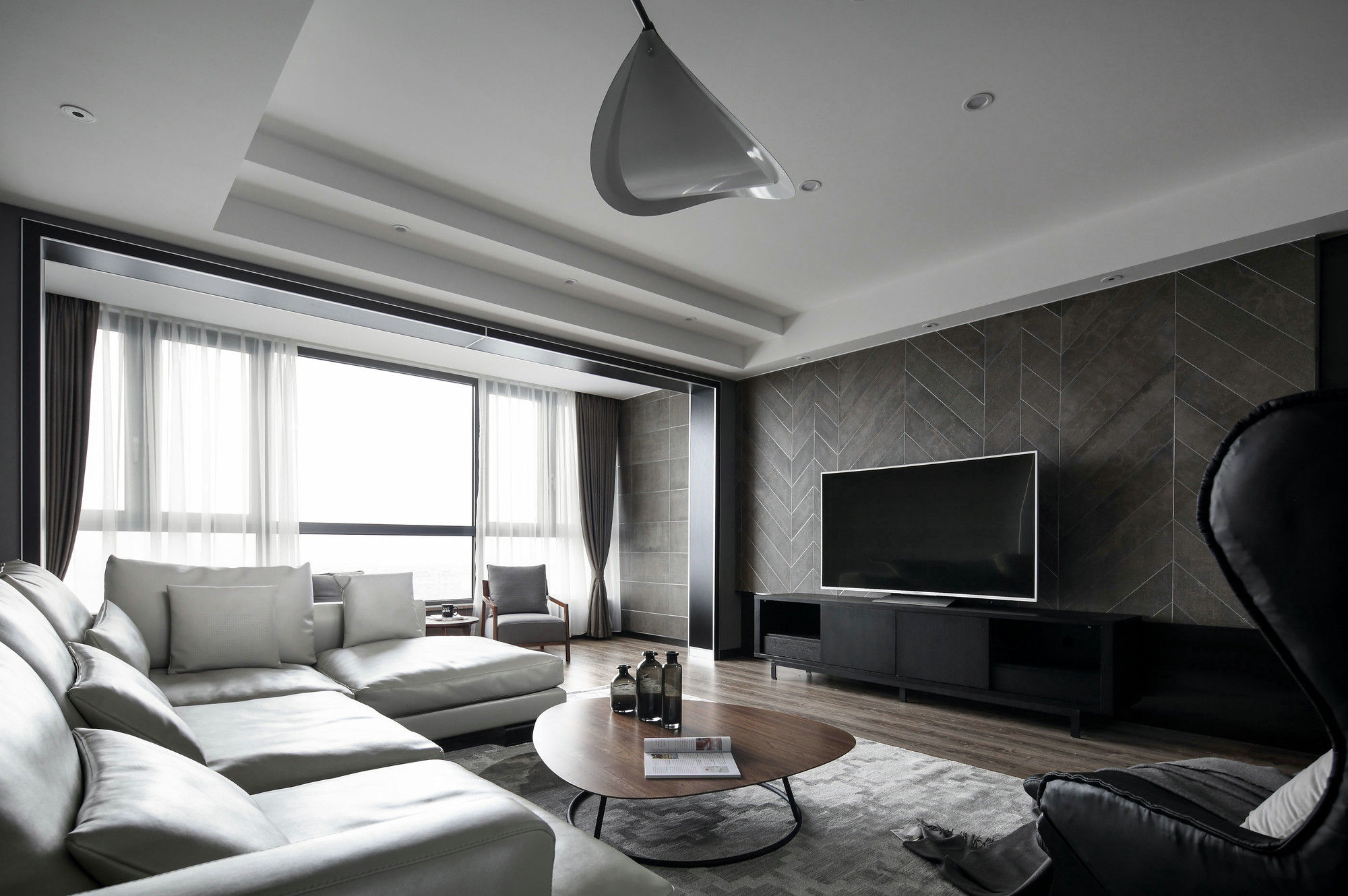 电视机背景墙以深咖色打底，搭配黑色电视机与地柜，营造出简约静谧的氛围。