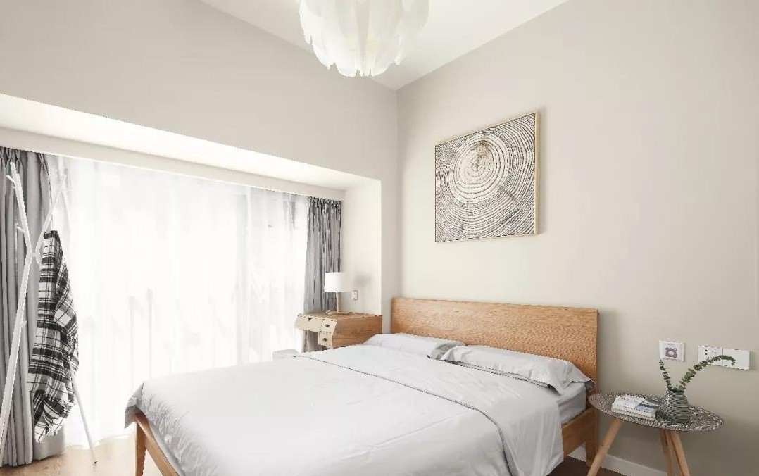 次卧背景墙使用白色基调，木质床头温润雅致，集合衣架节省空间又增加了储物能力。
