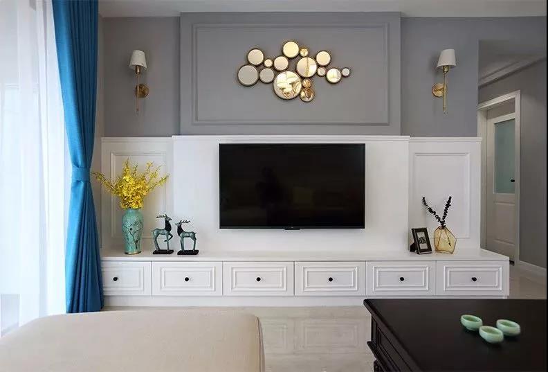 背景墙使用护墙板分层设计，在颜色上形成对比，丰富了客厅空间的视觉变化。