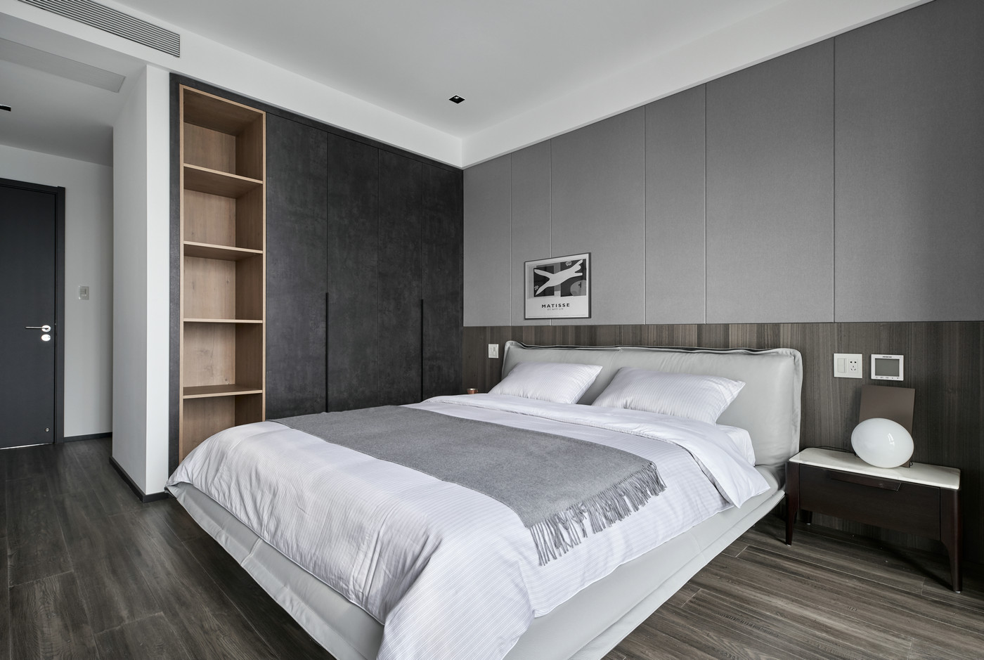 背景墙采用灰色调与木质分层设计，搭配深色衣柜饰面，体现出空间搭配的整体感。