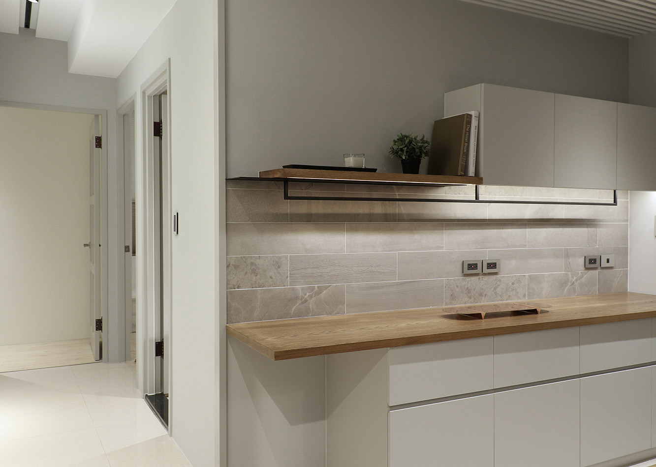 厨房整体色调温馨柔和，白色橱柜搭配木质工作台，优雅低调，明亮整洁。