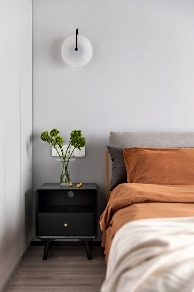 黑色床头柜搭配橘色枕饰品，将美学与舒适感融入其中，营造出美妙的睡眠氛围。 24