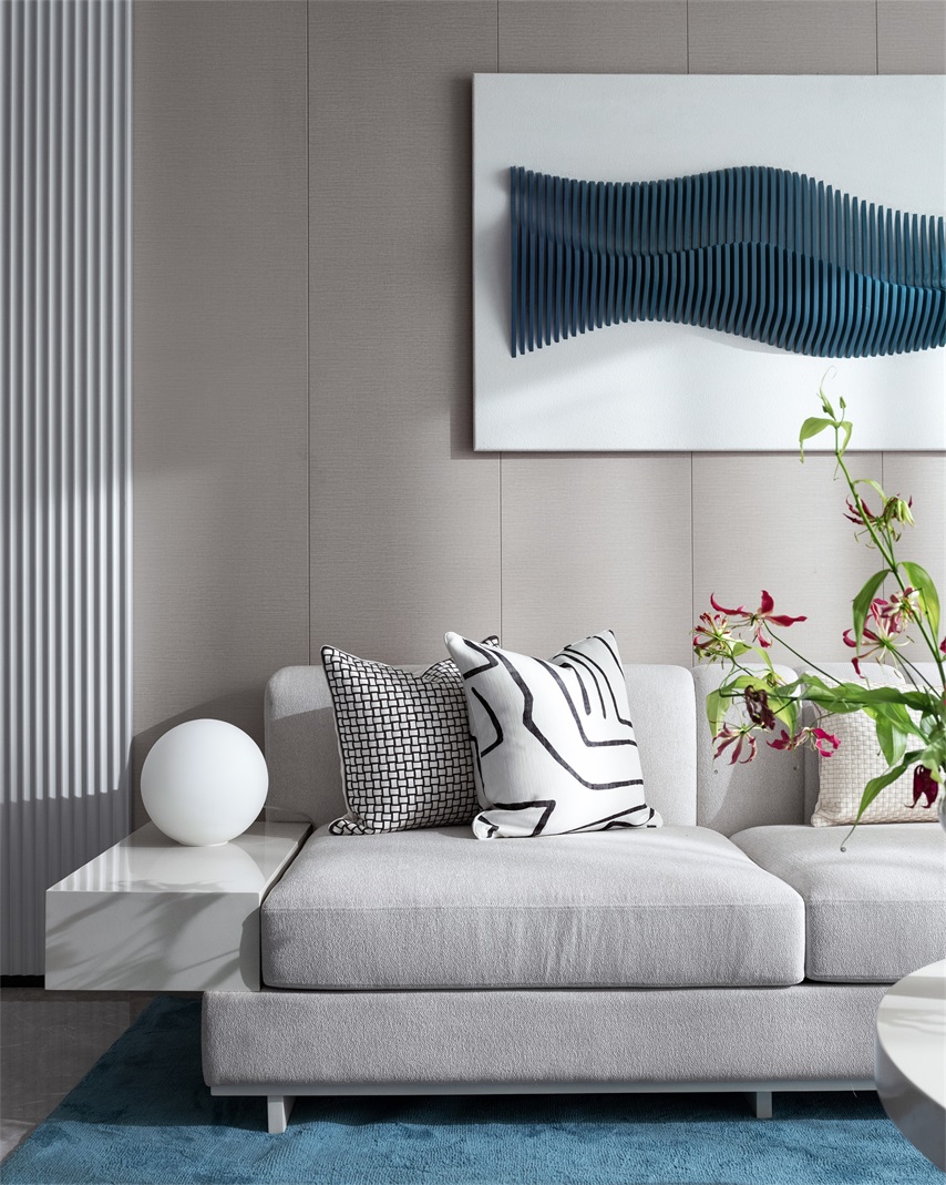 灰白色布艺沙发与米色背景墙设计搭配，打造出时尚温馨的客厅空间。