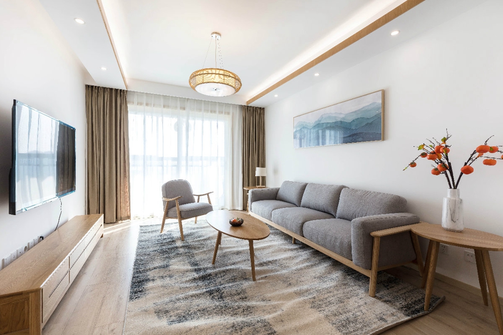 客厅的设计使用木质、灰色和白色搭配，呈现出日式风格氛围，营造出舒适放松的环境。