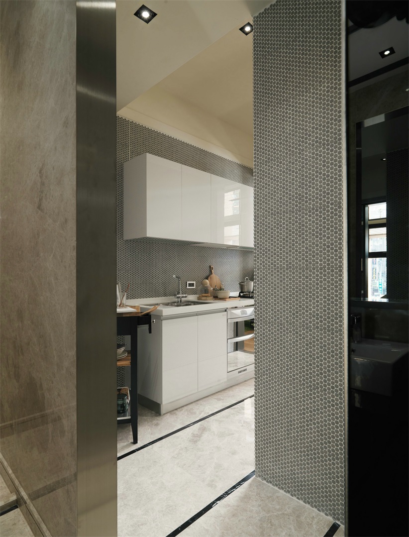厨房背景使用了带有高级灰纹路的材料铺贴，搭配白色橱柜，具有质感。