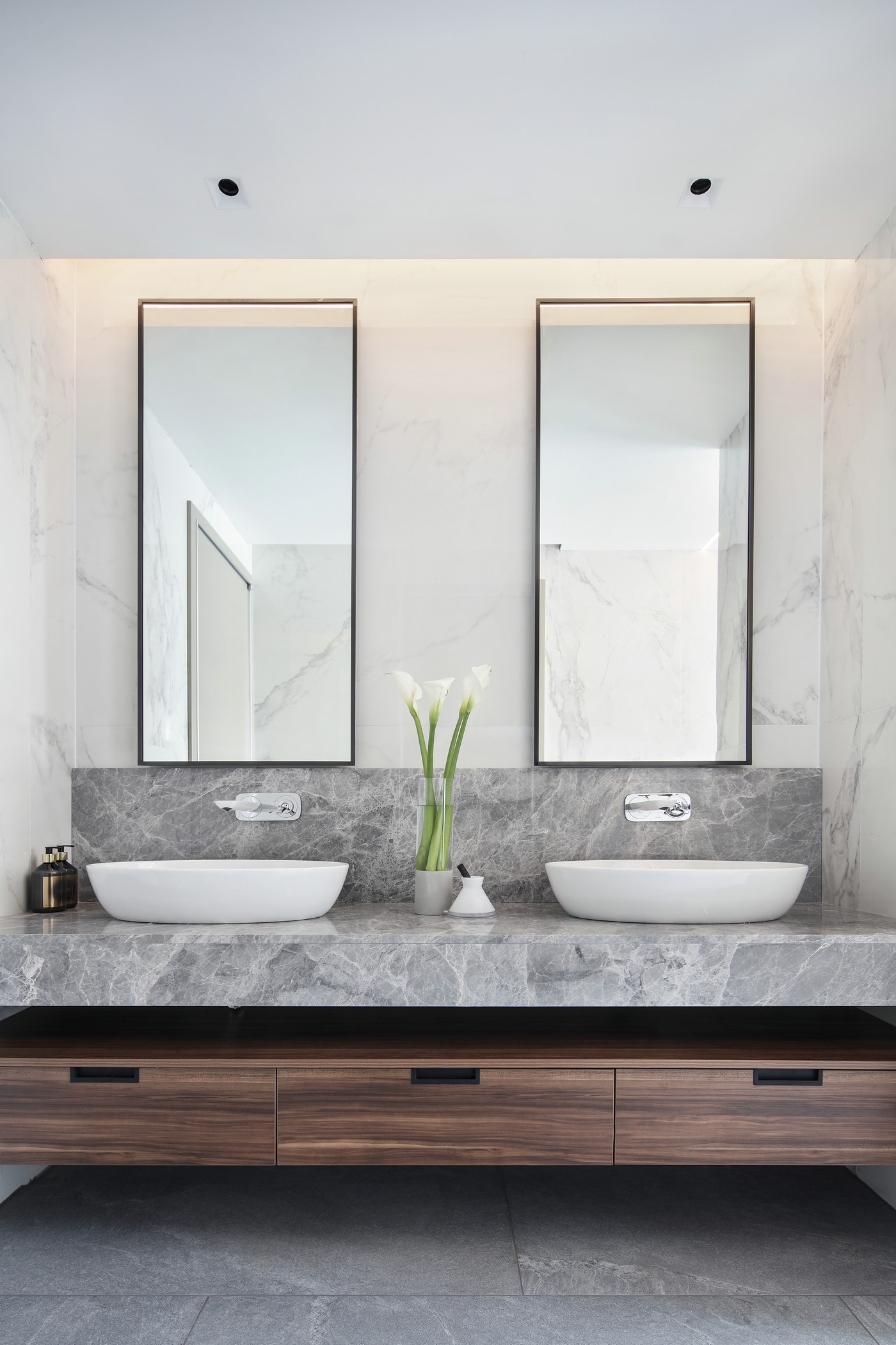 卫生间洗手池对称布局，视觉效果舒适，在顶部灯光的烘托下更有氛围感，空间层次分明。