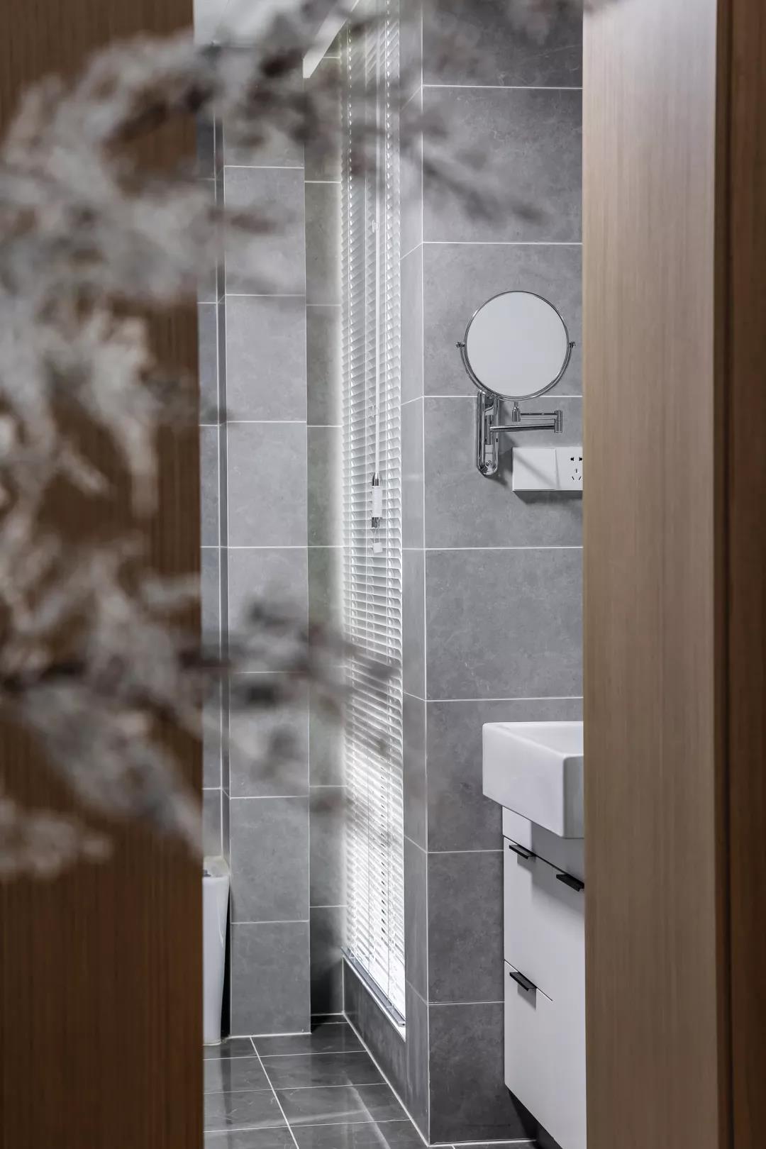 卫生间遵循整体设计一贯从简原则，以灰色为主基调，结合白色洁具，室内更加简洁静谧。