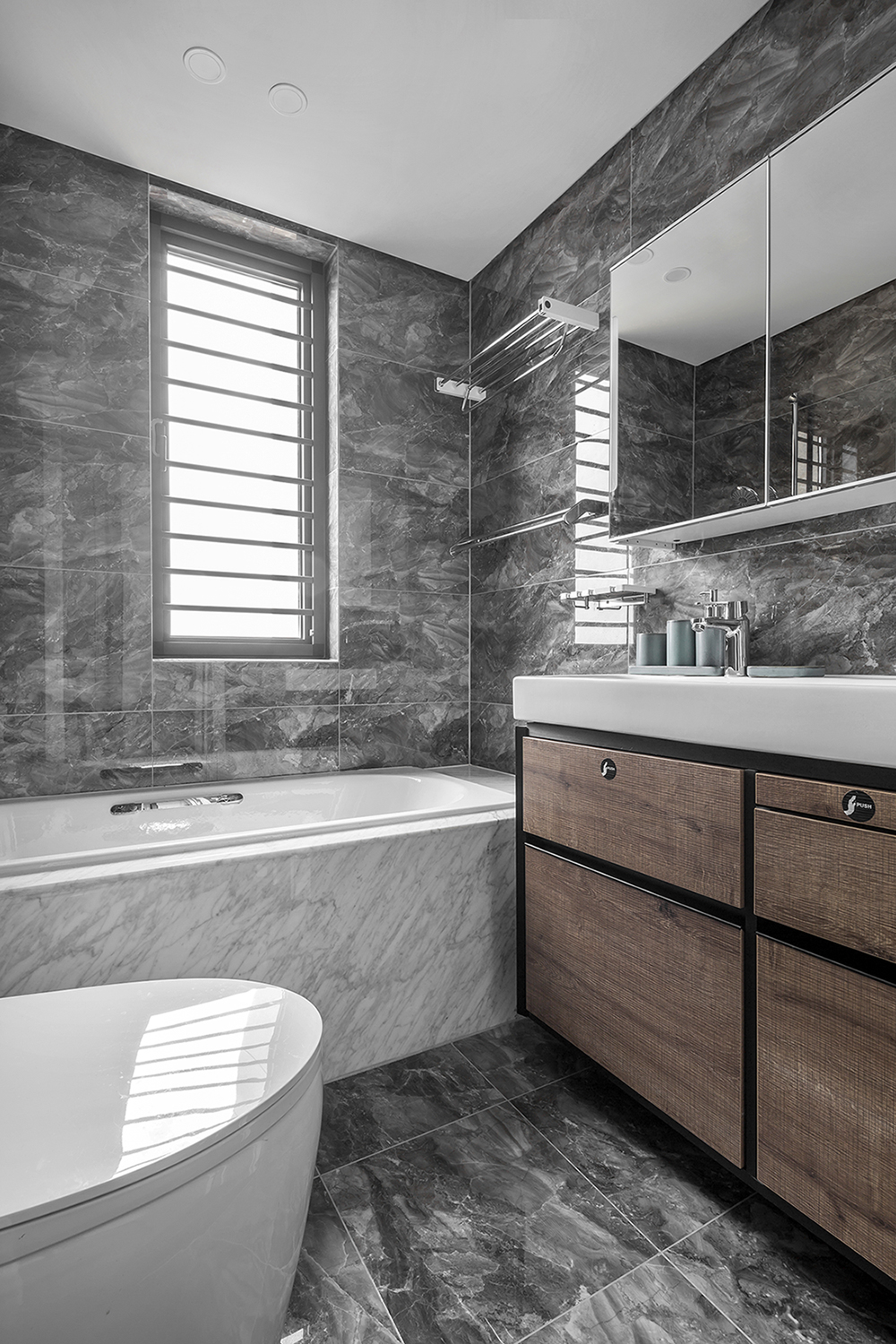 灰色背景墙与木色洗手台相互呼应，使卫浴空间十分典雅，不失稳重。
