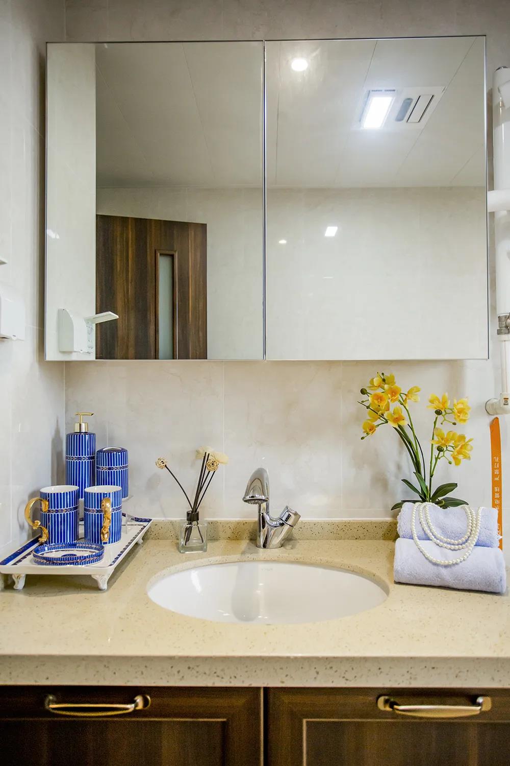 卫浴间整体颜色偏米色，洗手台盆上方设计了镜面柜，更增加高级感。