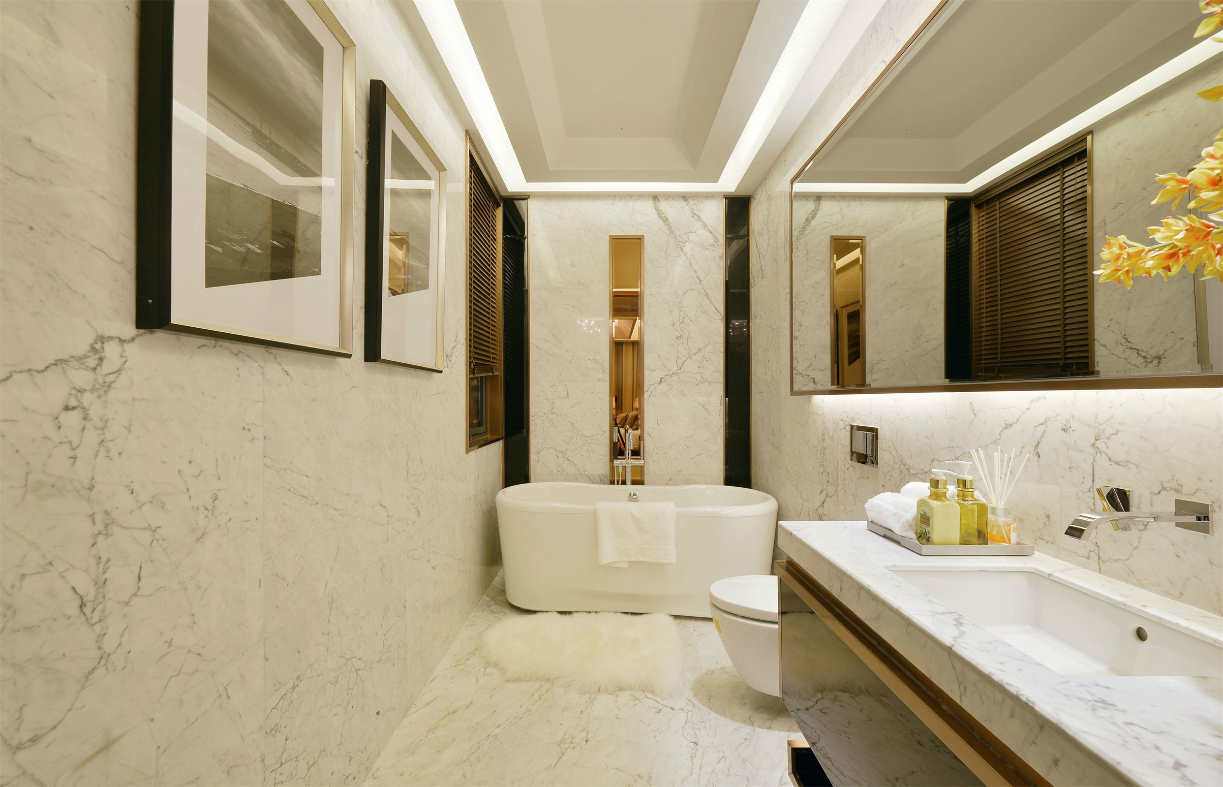 卫浴间干净整洁，浅色系搭配，浴缸背景墙镶以金色边框，凸显高级感。