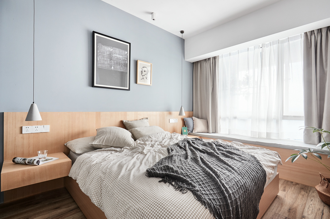 卧室背景墙分层设计，无床头设计简约大方，飘窗设计起到了延伸视觉的作用。