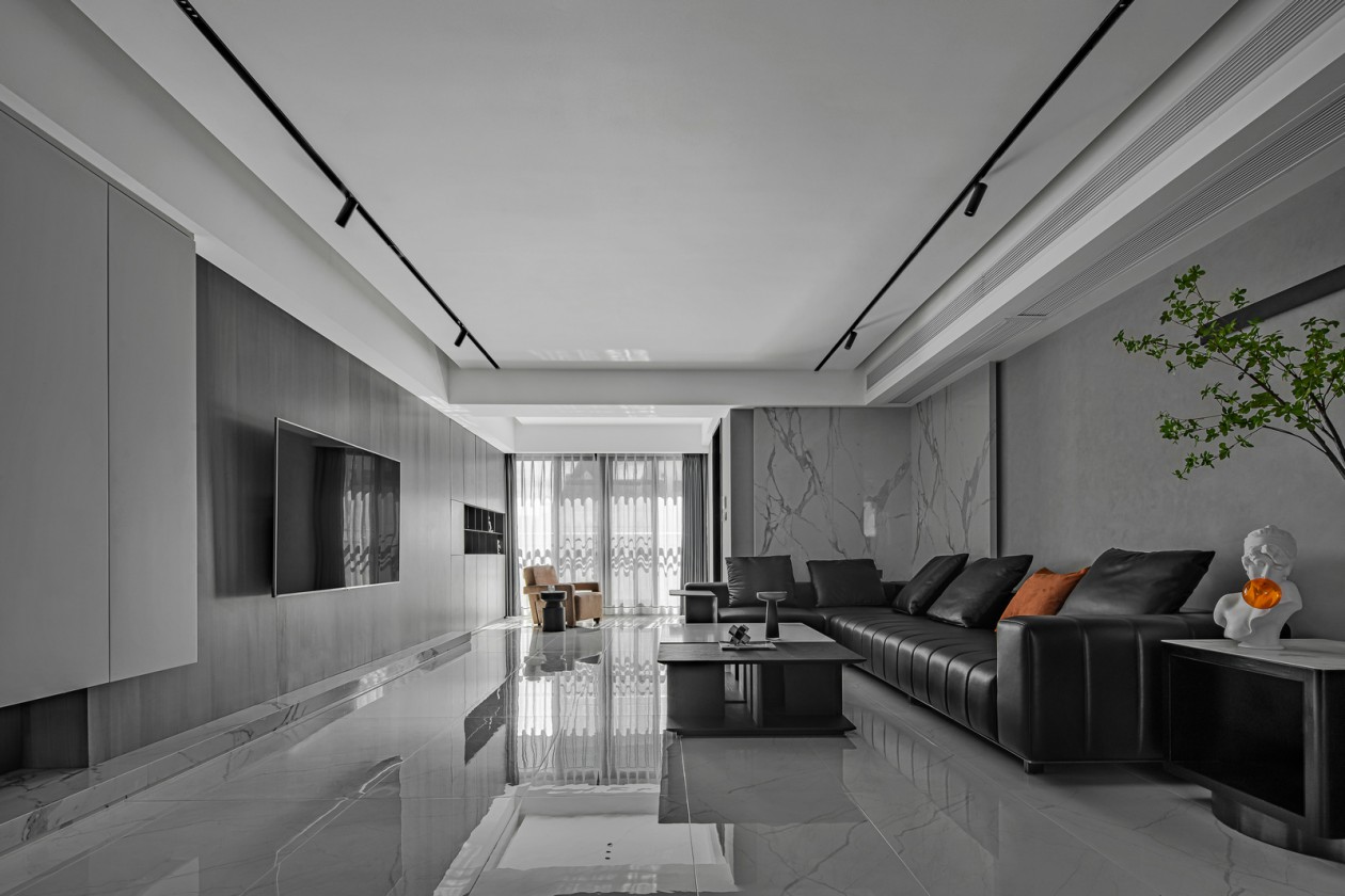 客厅以灰白色为底色，搭配黑色皮质沙发，透露生活的自然纯粹之感。
