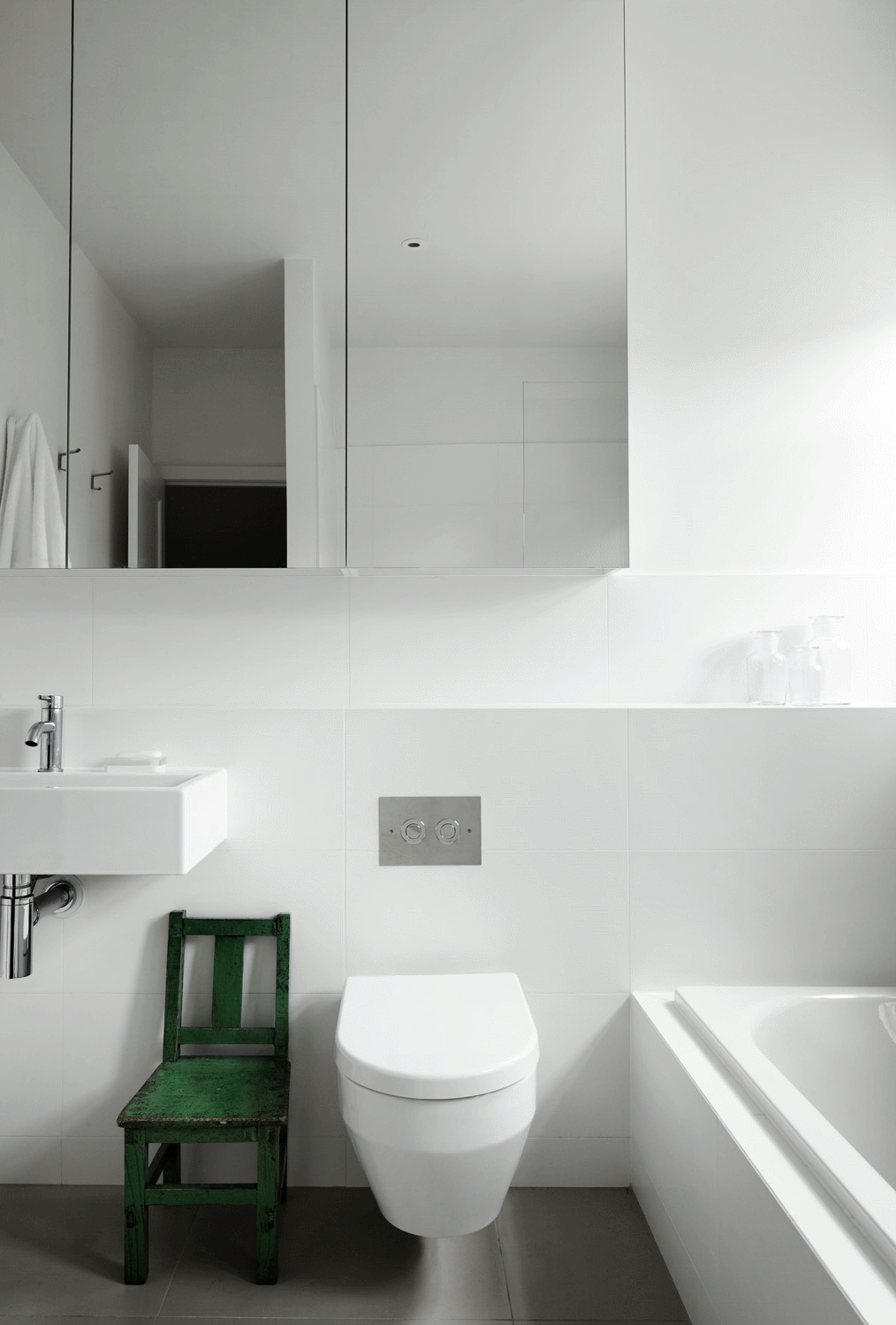 卫生间明亮干净，带来一种自然舒适的感觉，绿色椅凳成为空间点缀。 