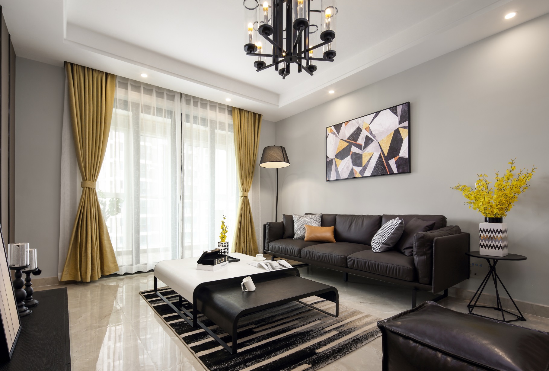 客厅空间主要以黑白灰进行搭配，凸显出美式风格的稳定氛围，跳色软装增加了一份活跃感。