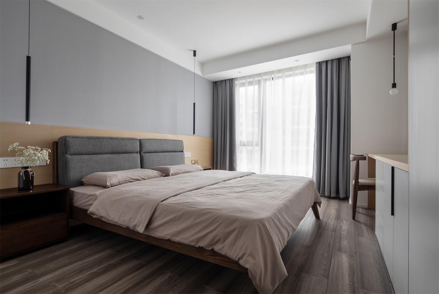 主卧灰色基调与木色元素搭配，加之垂吊灯具烘托，呈现出淡雅轻松的睡眠环境。