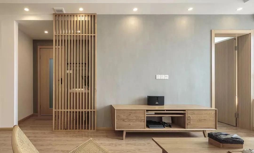 客厅背景墙设计简单，木质隔断增强室内私密感，整个空间便有了一种温柔香醇的视觉感受。