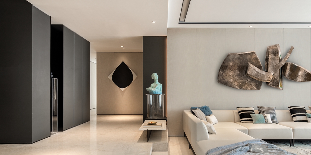 白色布艺沙发搭配米色背景墙，显得格外温馨，金属装饰元素与空间形成对比。