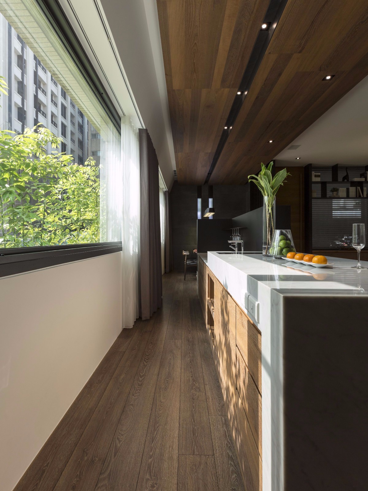 厨房延续木质的主基调，局部采用白色工作台渲染，营造出精致明亮的烹饪空间。