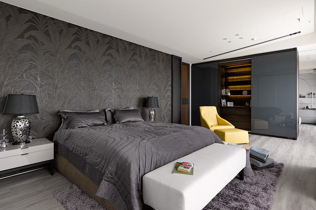 侧卧背景墙造型让空间更有美感，别致的黄色单人沙发增添灵动感。